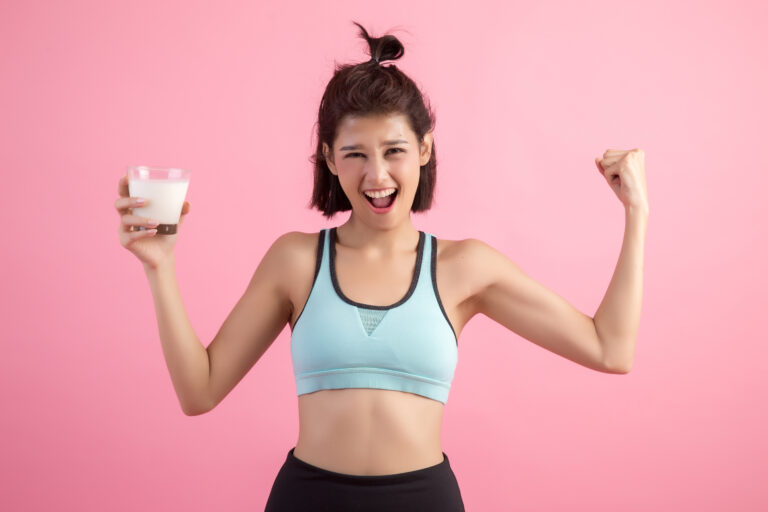 Mujer con músculos sujetando un vaso de leche