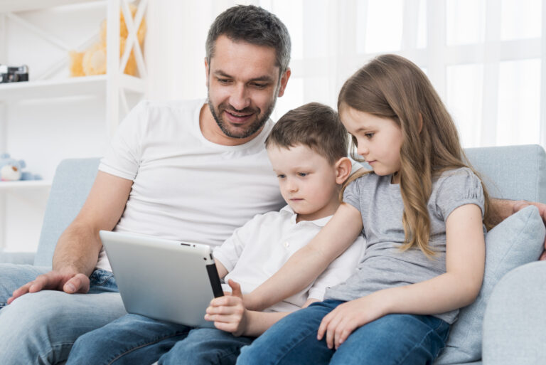 Padre con sus hijos usando una tablet